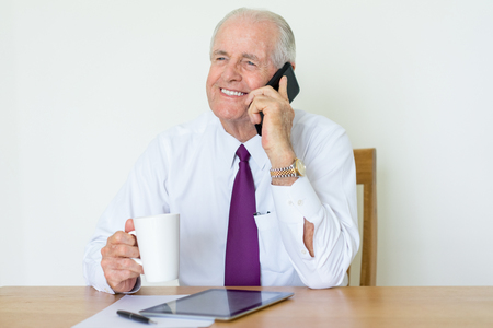 Smiling Boss Talking on Phone at Office Deskの写真素材