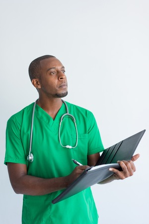 Portrait of concentrated young general practitioner with folder. African American physician wearing...