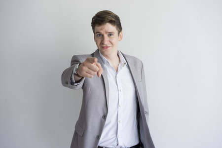 Confident ambitious handsome young businessman pointing to camera. Successful business trainer choosing you. Motivation conceptの写真素材