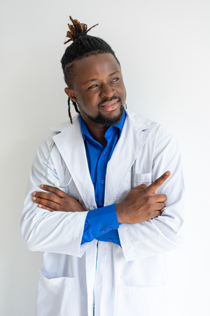 Smiling confident leading doctor in lab coat pointing aside. Proud purposeful medical specialist looking away and gesturing. Medical goals conceptの写真素材