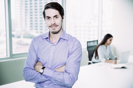 Confident businessman standing with folded arms