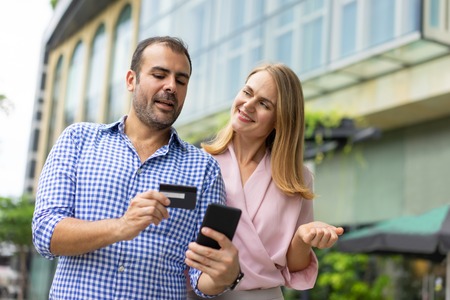 Serious mid adult man explaining to wife how to use online bankの写真素材