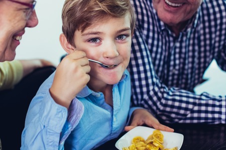 Grandparents and Grandson Eating Sliced Bananaの写真素材