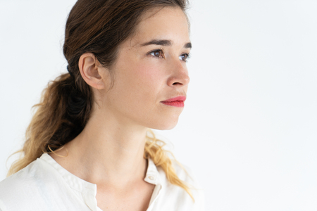 Serious beautiful young brown-haired woman. Woman portrait concept. Isolated view on white background.の写真素材