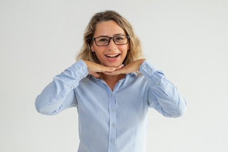 Happy excited lady leaning head on hands and looking at camera. Cheerful optimistic businesswoman in glasses looking interested. Listening conceptの写真素材