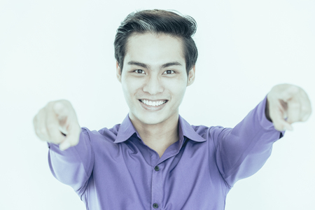 Cheerful successful Asian businessman pointing to camera and choosing you. Positive male speaker gesturing during presentation. Choice conceptの写真素材