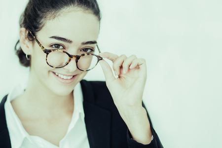 Portrait of young Caucasian businesswoman or student wearing glasses looking at camera and smilingの写真素材