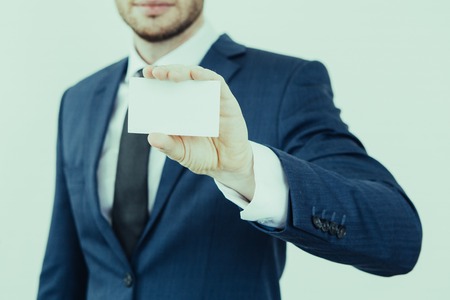 Male consultant presenting himself and showing business card. Close-up of manager holding white card. Information about individual conceptの写真素材