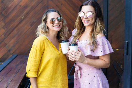 Two stylish women drinking coffee in cafe.の写真素材