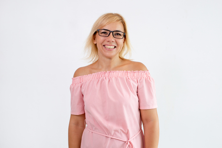 Happy pretty woman posing and looking at camera. Positive woman wearing summer dress and glasses. Woman portrait concept. Isolated front view on white background.の写真素材