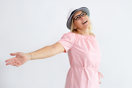 Happy woman wearing hat and spreading arms. Positive lady wearing summer dress. Happiness concept. Isolated view on white background.の写真素材
