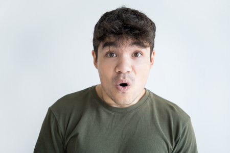 Portrait of surprised young Asian man looking at camera. Face of Vietnamese male student with shocked expression. Surprise or confusion conceptの写真素材