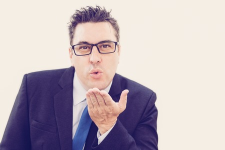 Handsome businessman blowing kiss to camera while flirting. Confident successful businessman sending...