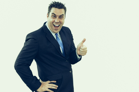 Cheerful emotional businessman giving good assessment showing thumb up. Hilarious excited handsome male manager enjoying success. Winning conceptの写真素材