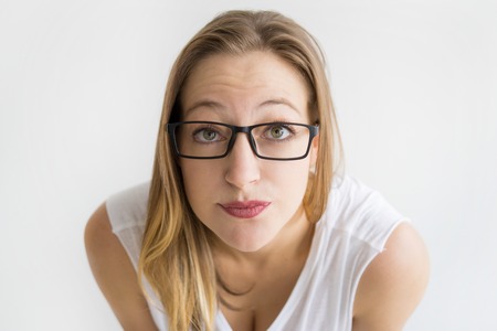Focused woman wearing glasses and staring at camera. Pretty lady. Attention concept. Isolated front view on white background.の写真素材