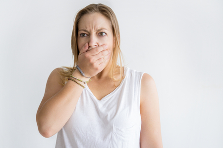 Shocked woman covering mouth with hand. Dissatisfied lady looking away. Shock concept. Isolated front view on white background.の写真素材