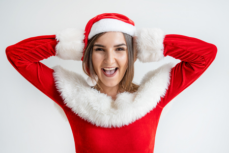 Excited woman in Santa Claus outfit covering ears with hands. Portrait of young Caucasian girl ignoring noise. Do not want to hear conceptの写真素材