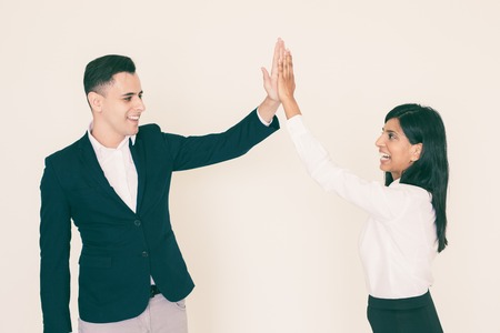 Portrait of successful young partners, Indian businesswoman and North American businessman giving five. Success and partnership conceptの写真素材