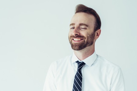 Successful business man smiling, winking and looking at camera. Business leader concept. Isolated front view on white background.の写真素材
