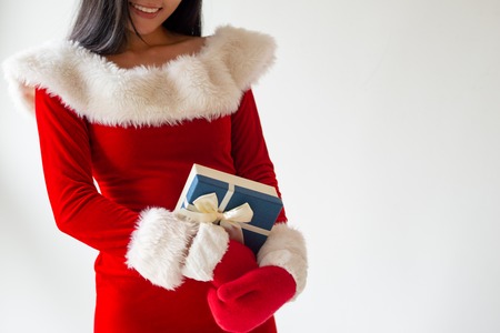 Cheerful girl in Christmas costume happy about her gift. Smiling woman holding present box. Giving gifts conceptの写真素材