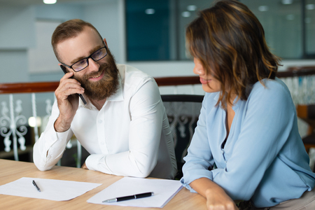 Positive business colleagues working on new project in office. Smiling bearded marketing specialist offering idea to colleague. Brainstorming conceptの写真素材