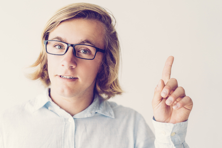 Portrait of confident guy in glasses showing attention gesture. Caucasian student having idea. Attention or idea conceptの写真素材
