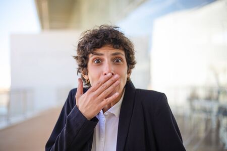 Shocked businesswoman closing mouth. Close-up view of emotional middle aged woman in formal wear...