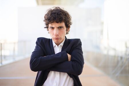 Unhappy businesswoman looking at camera. Upset middle aged woman in formal wear standing with crossed arms and looking at camera. Emotion conceptの写真素材