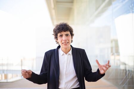 Scared businesswoman looking at camera. Unhappy middle aged businesswoman in formal wear gesturing with hands and looking at camera. Emotion conceptの写真素材