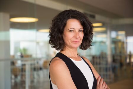 Positive confident business woman in casual posing in office hall. Middle aged businesswoman with...