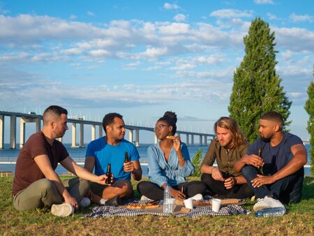 Happy people talking and drinking beer during summer picnic. Good friends talking and drinking beer....