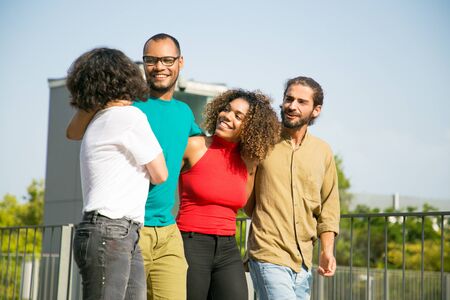 Happy multiethnic friends enjoying walking outdoors. Mix raced group of people walking outside, hugging each other, talking and laughing. Friendship and lifestyle conceptの写真素材