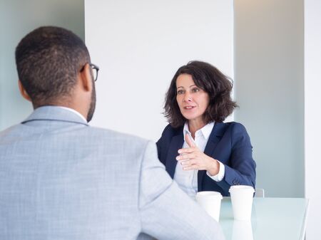 Personnel manager and job applicant meeting for interview. Business man and woman sitting at meeting...