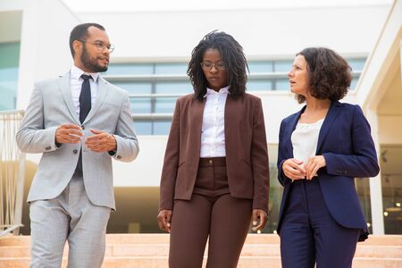 Business colleagues walking and talking. Professional multiethnic business team in formal wear walking and talking together. Cooperation conceptの写真素材