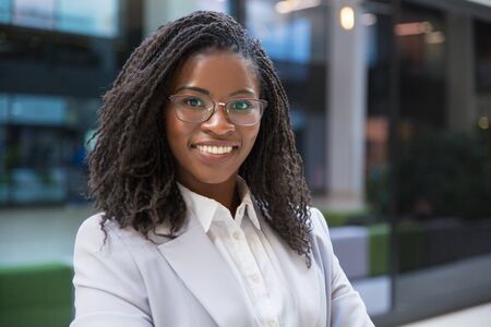 African American businesswoman smiling at camera. Portrait of cheerful young businesswoman in formal wear standing and looking at camera. Business conceptの写真素材