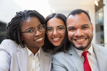 Multiethnic business colleagues smiling at camera. Portrait of happy young business people smiling at camera together. Cooperation conceptの写真素材