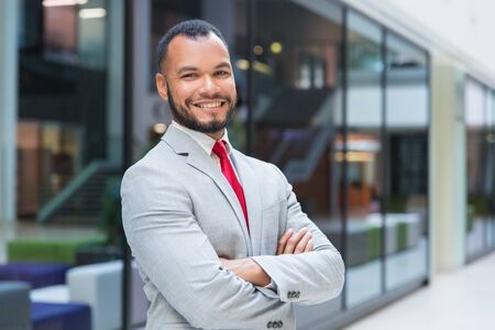 Cheerful businessman smiling at camera. Portrait of confident African American businessman in suit...