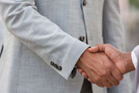Closeup of handshake. Business people in office suits shaking hands. Dealing conceptの写真素材
