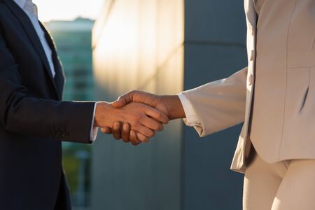 Female business leaders greeting each other with handshake. Business women in office jackets shaking hands outside. Successful deal conceptの写真素材