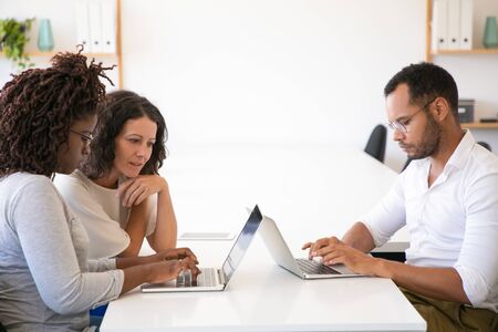 Diverse business colleagues meeting and working on project together. Man and women in casual sitting...