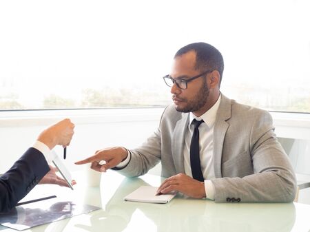 Businessman pointing at digital tablet. Cropped shot of business colleagues working with tablet pc in office. Wireless technology conceptの写真素材
