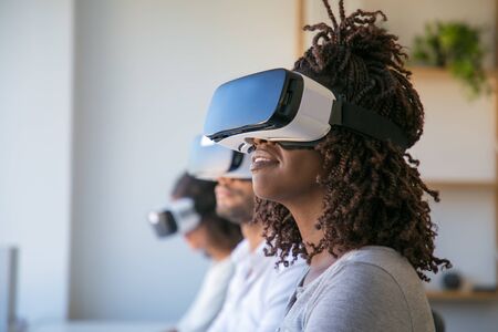 Excited users testing VR game. Diverse group of people wearing VR headset, turning face up. Virtual...