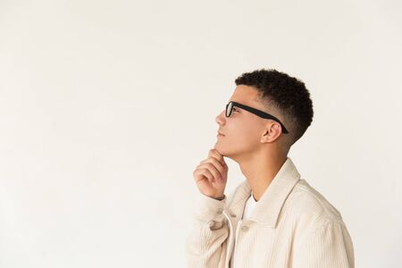 Pensive man in eyeglasses looking away. Side view of thoughtful young man wearing spectacles,...