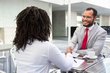 Smiling businessman shaking hands with partner. Cheerful businesspeople reaching agreement. Handshake conceptの写真素材