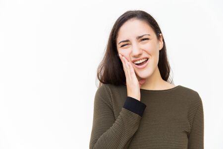 Upset woman with pain grimace suffering from toothache. Young woman in casual standing isolated over...