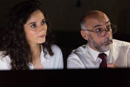Businessman and businesswoman in dark office. Close-up view of professional male and female business...