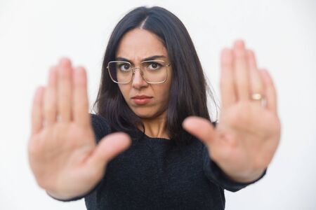 Scared upset woman making stop gesture with both hands. Beautiful young woman in casual sweater...