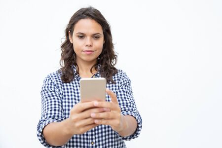 Smiling woman using mobile phone. Front view of beautiful happy young woman using smartphone on...