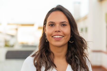 Closeup shot of beautiful laughing woman. Attractive young lady with long hair looking at camera. Happiness conceptの写真素材