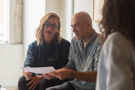 Concentrated home owners choosing color palette for home. Thoughtful mature couple looking at...